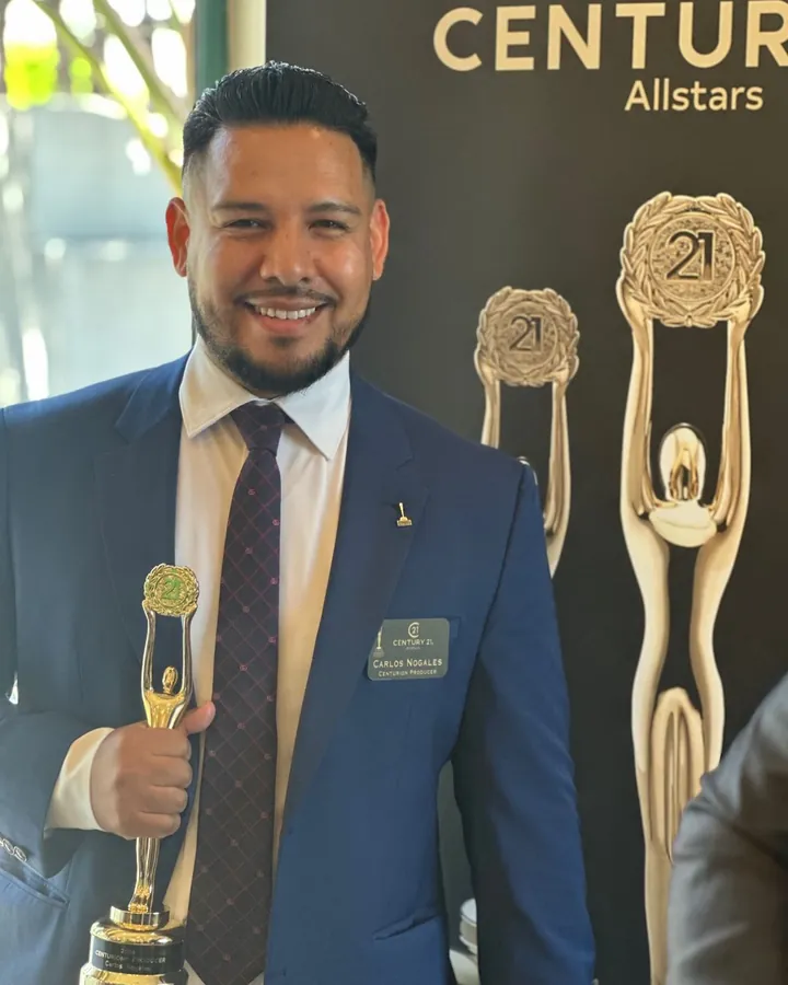 Carlos Nogales holding his Century 21 CENTURION Producer award at a Century 21 Allstars event